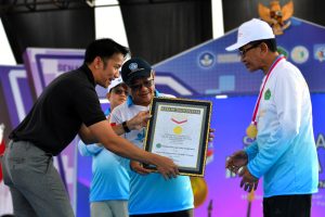 Senior Manager MURI, Triyono menyerahkan Rekor MURI kepada Bupati Pamekasan Kholilurrahman didampingi Mendikdasmen Abdul Mu'ti.
